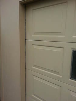 A suburban residential home in Garland Texas with a garage door missing the weather seal so Action Garage Doors dispatch technician 2