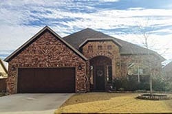 A custom residential wood double car garage door installed and repaired in Mansfield Texas by Adan Vega of Action Garage Doors