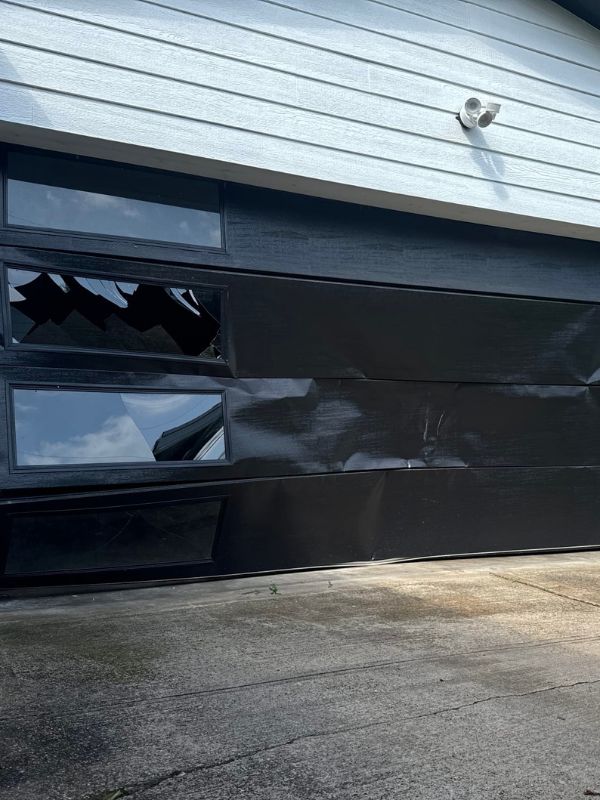 A garage door that has been heavily damages. 