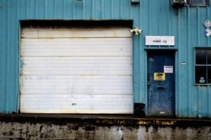 Broken, falling down commercial garage door with text saying Quick, Fast, Same Day Service!