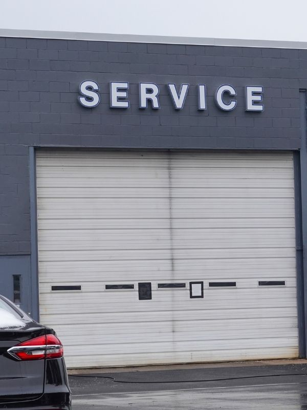 An overhead garage door at an auto dealership. 